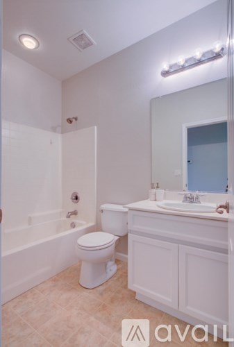 A white bathroom with a toilet, sink, and bathtub.