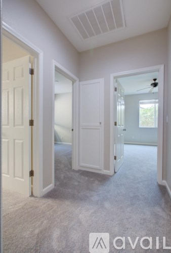 A room with white doors and carpeted floor.