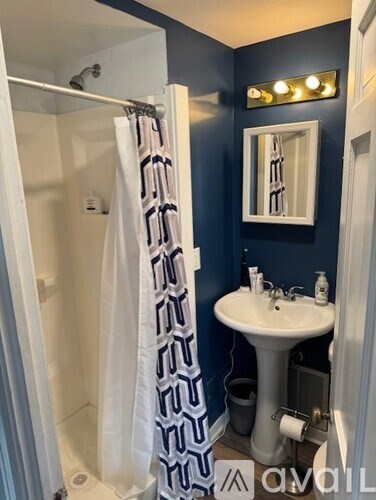 A bathroom with a white sink and a shower with a white curtain.