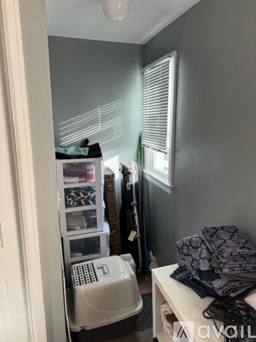 A small room with a white fridge and a white cabinet.