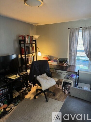 A room with a desk, chair, and bookshelf.