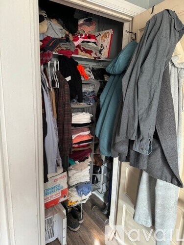 A closet is packed with clothes and other items.