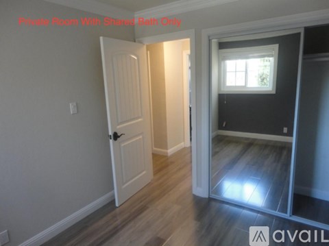 A room with a desk and chair in front of a window.