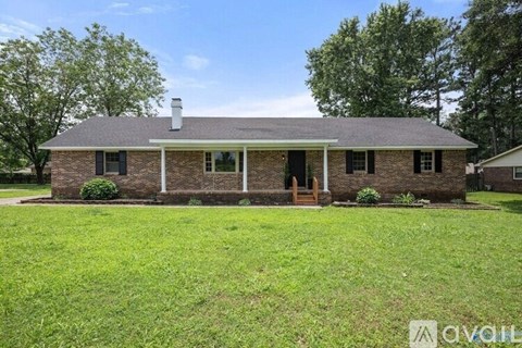 A brick house with a green lawn in front.