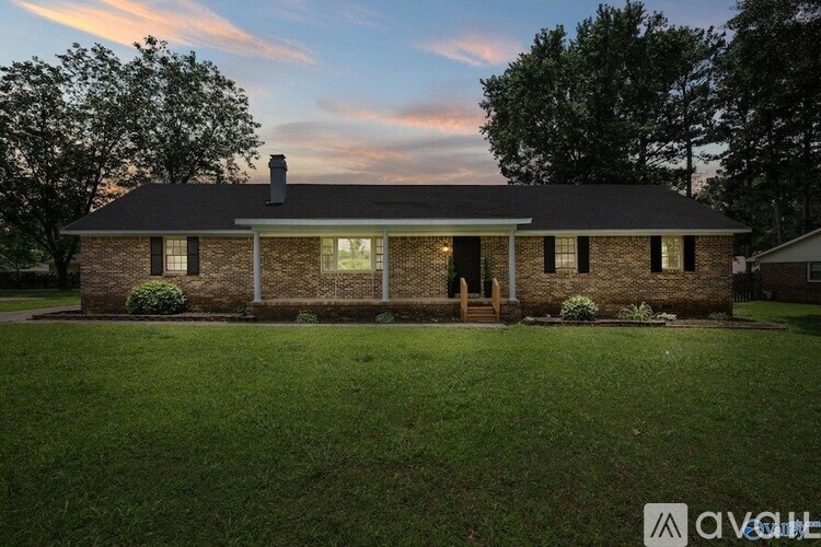 A house with a brick facade stands in a grassy yard.