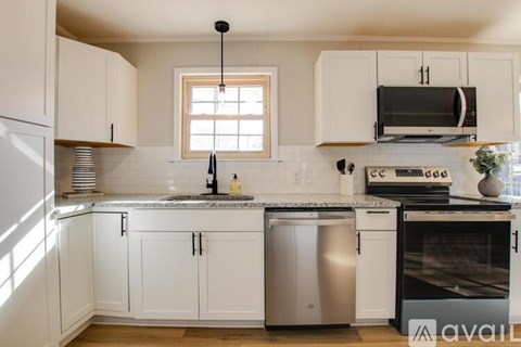 A kitchen with white cabinets and a granite countertop.
