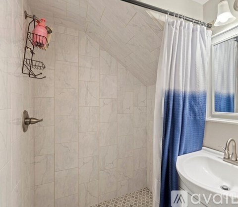 A bathroom with a white sink and a shower curtain.