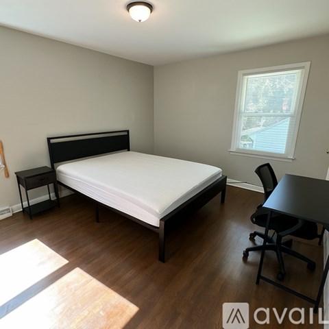 A bedroom with a bed, nightstand, and chair.