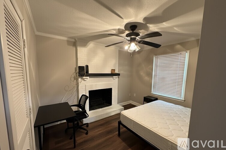 A bedroom with a large bed and a painting of a cityscape on the wall.