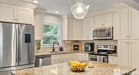 A kitchen with a stainless steel refrigerator, microwave, oven, and other appliances.