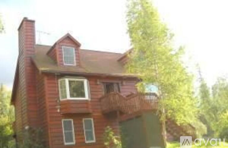 A red brick house with a balcony on the second floor.