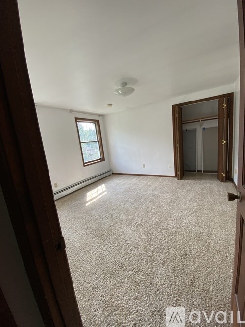 A room with a carpeted floor and a window.