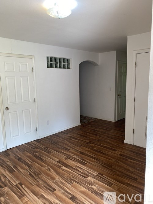 A room with wooden flooring and a white door.