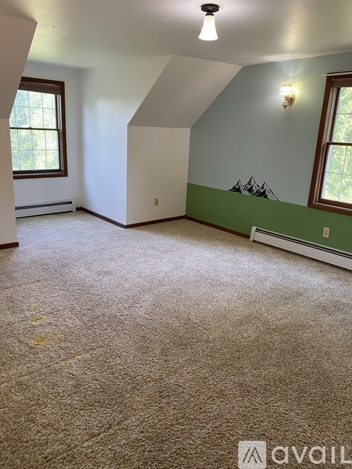 A room with a carpeted floor and a window.