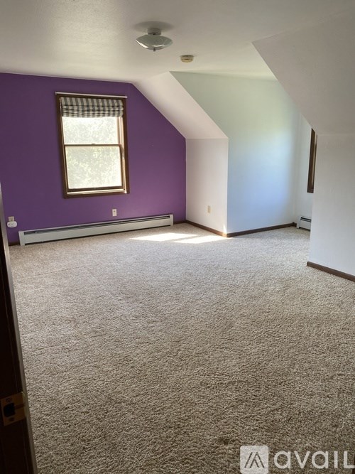 A room with purple walls and a window.