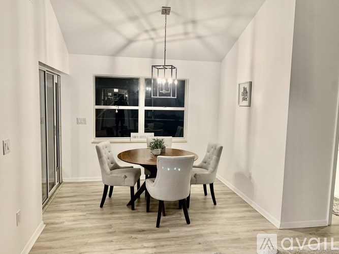A modern dining room with a round table and chairs.