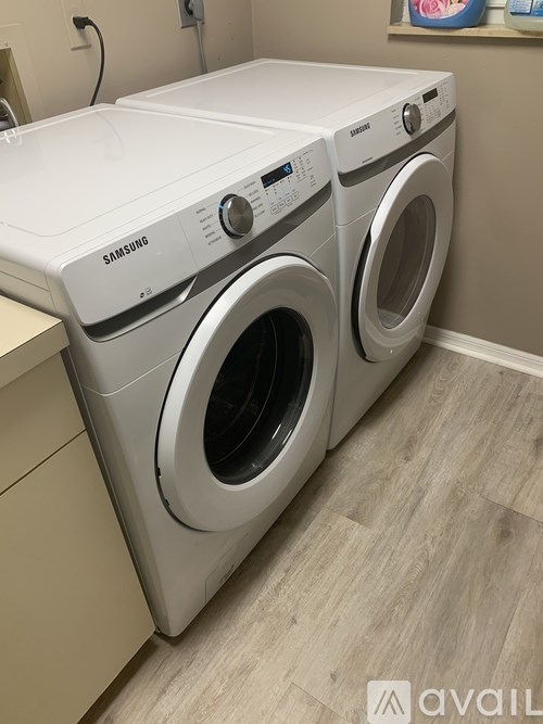 A Samsung washing machine and dryer in a laundry room.