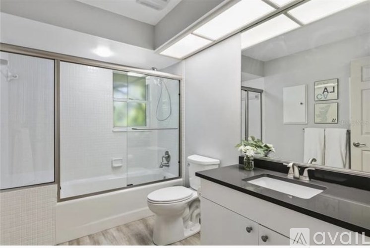 A garage with a closed grey door and a white wall.