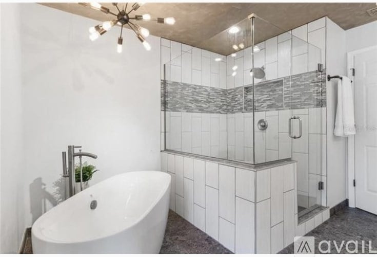 A white bathroom with a freestanding tub and a walk-in shower.