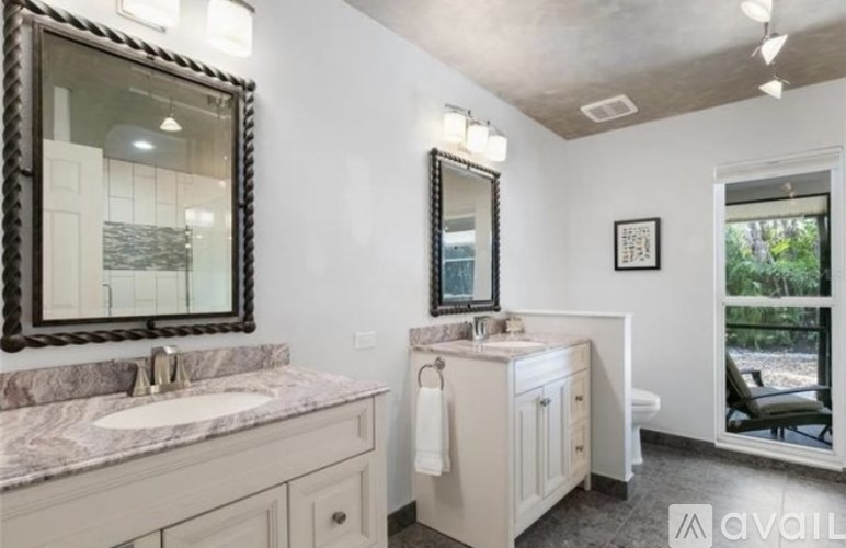 A bathroom with a marble countertop and a large mirror above it.