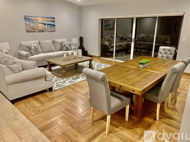 A living room with a wooden table and grey chairs.