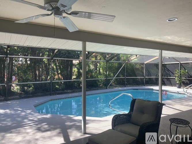 A patio with a pool and a chair.