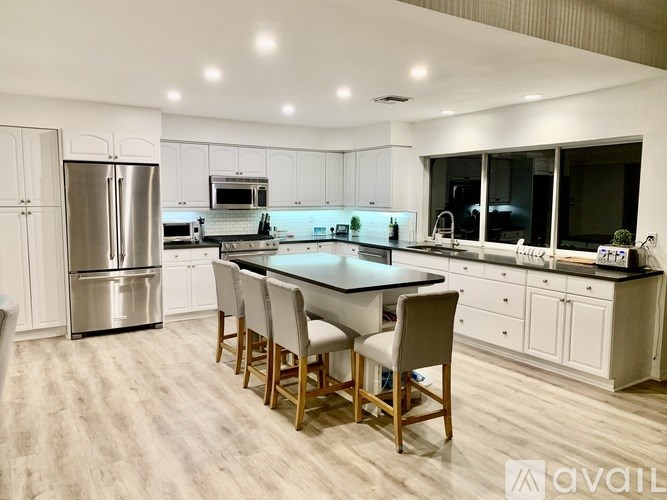 A modern kitchen with a large island and stainless steel appliances.