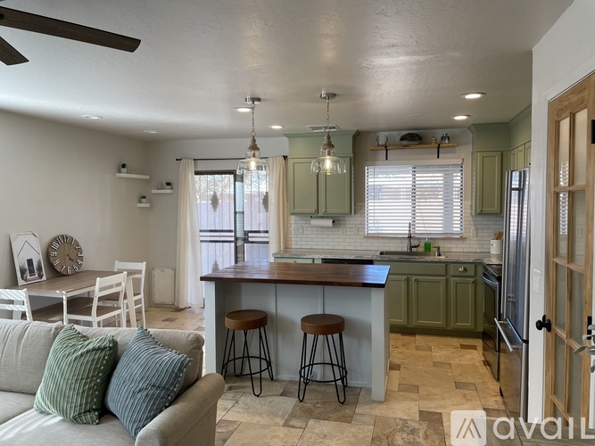 A kitchen with a bar stool and a couch.