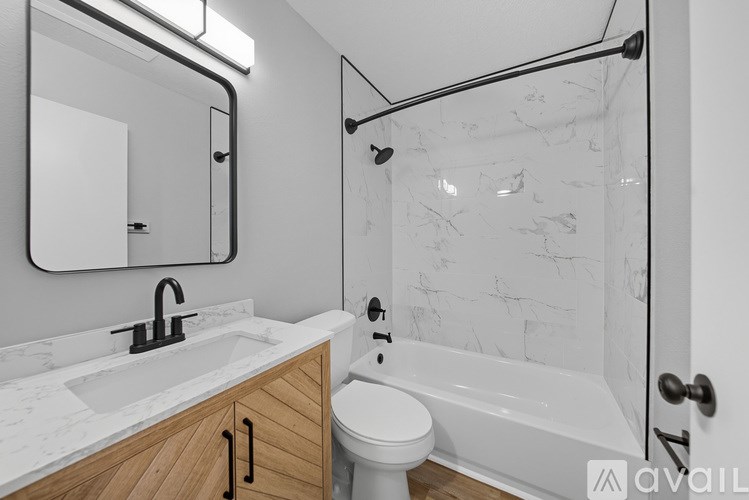 A bathroom with a white marble shower and a white toilet.