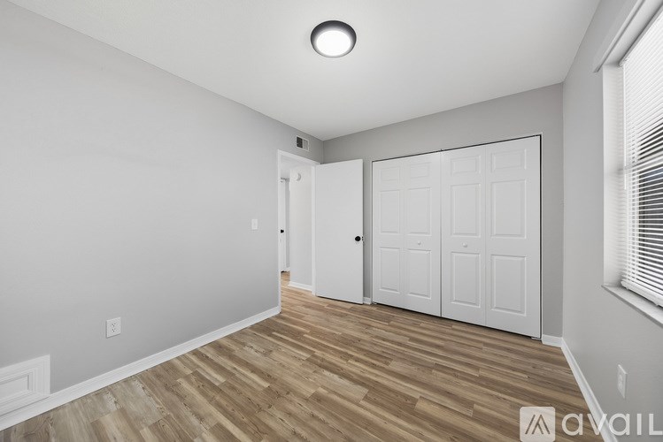 A room with a white door and a window with blinds.