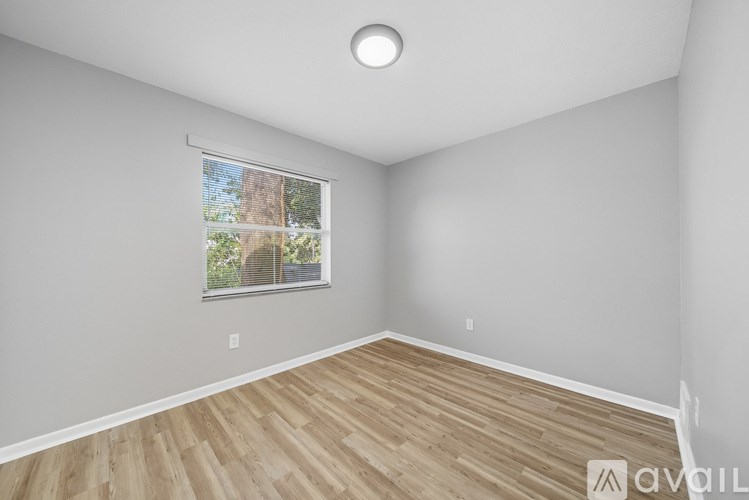 A room with a window and wooden flooring.