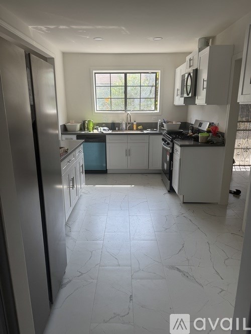 A kitchen with a marble floor and a window.