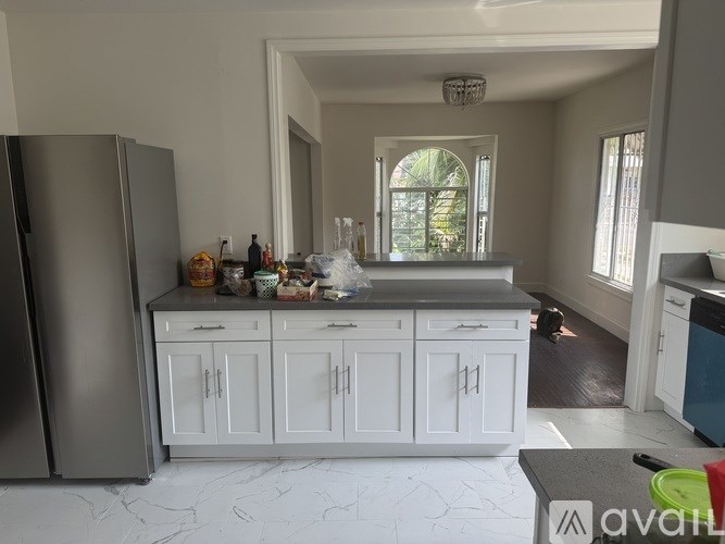 A kitchen with white cabinets and a grey countertop.