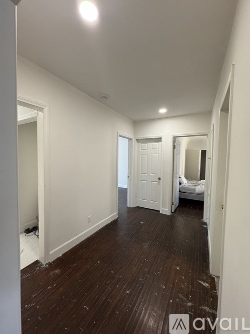 A room with white walls and wooden floors is available for rent.
