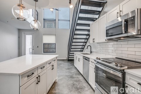 A kitchen with white cabinets and a stainless steel stove top.