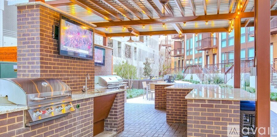 A patio with a barbecue grill and a TV on the wall.