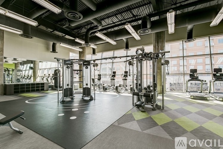 A gym with a variety of equipment including treadmills, weights, and exercise machines.