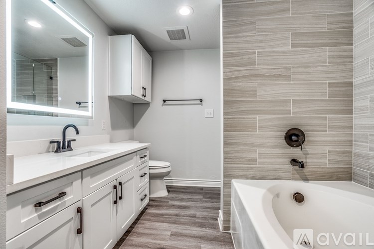 A modern bathroom with a white tub and a walk-in shower.