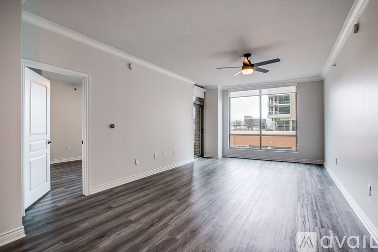 A spacious room with a ceiling fan and wooden flooring.