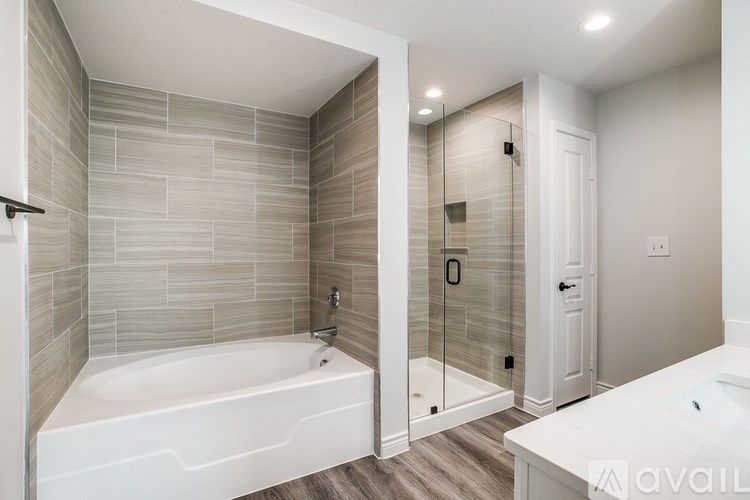 A bathroom with a white tub and a walk-in shower.