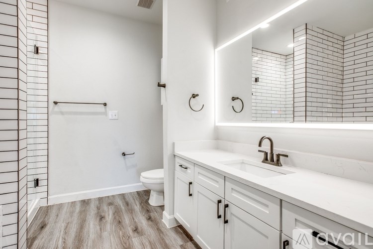 A bathroom with a white sink and a white toilet.