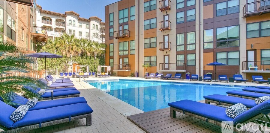 A pool surrounded by lounge chairs and umbrellas.