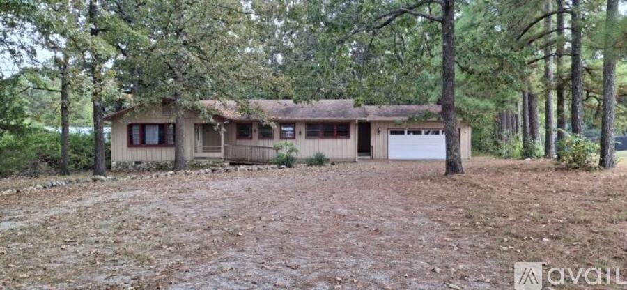 A house with a brown roof is surrounded by trees.