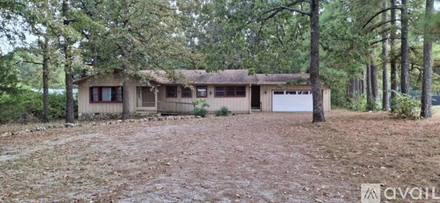 A house with a brown roof is surrounded by trees.
