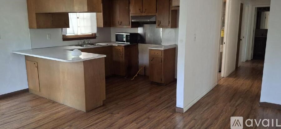 A kitchen with wooden floors and cabinets.
