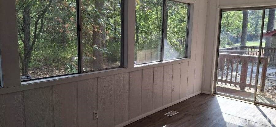 A room with a view of trees through the windows.