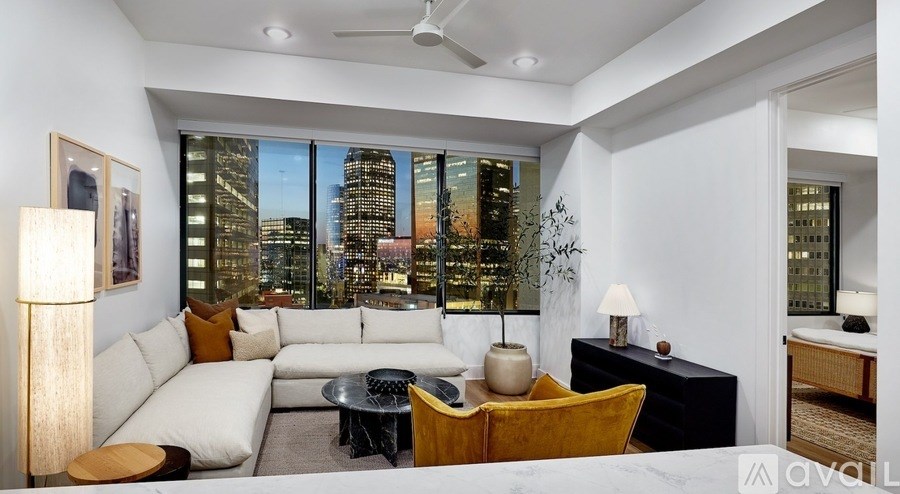 A living room with a large window overlooking a cityscape.