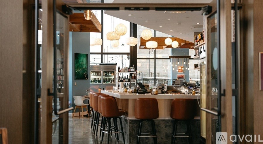 A modern restaurant with a bar area and a view of the city.