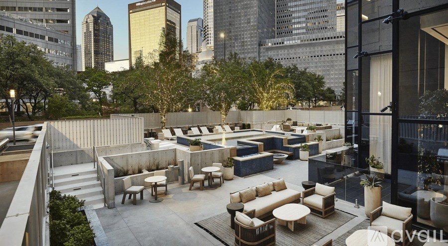 A rooftop patio with tables and chairs overlooking a city skyline.