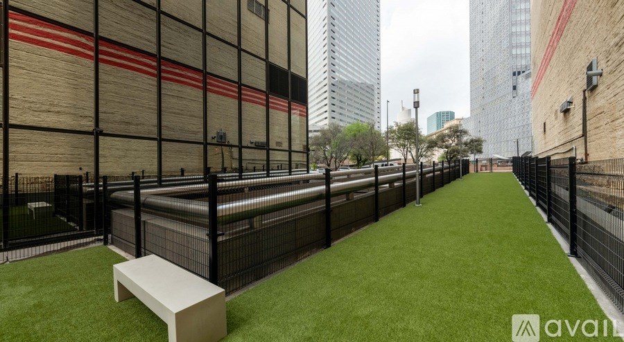 A long, narrow outdoor space with a bench and a fence.